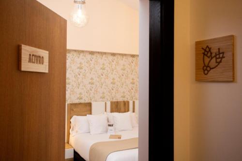 a hotel room with two beds and a window at O Camiño Fala Hotel in Mazaricos