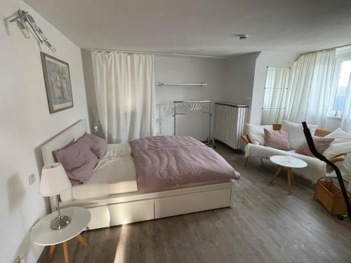 a white bedroom with a bed and a couch at Ferienwohnung Körnernest in Ettringen