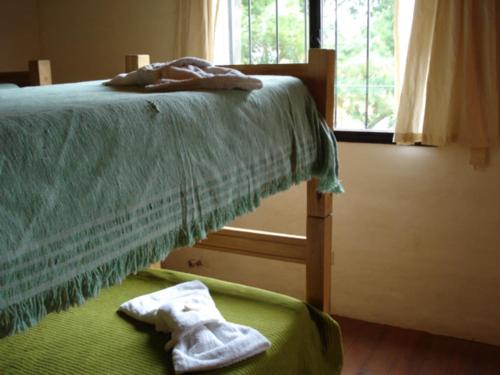 a bedroom with a bed with green sheets and a window at Cabañas Buena Vista in Los Cocos
