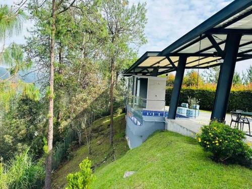 a house with a stove in a field with trees at Villa near the airport and Medellin in El Retiro