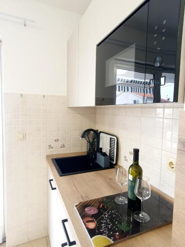 a kitchen with two glasses of wine on a counter at Diana apartment in Gabonjin