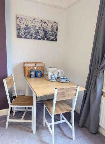 a wooden table with two chairs and a table with a tea set at Mitton Villa in Stourport