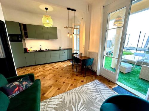 un salon avec une table et une cuisine avec une fenêtre dans l'établissement Wonderful apartment and garden heart of Nice, à Nice
