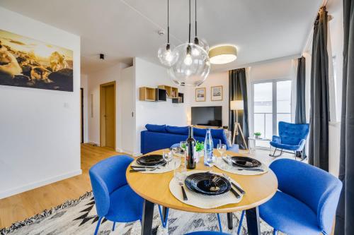 a dining room with a table and blue chairs at ReVital Mechelinki by Homeprime Parking Free in Mechelinki