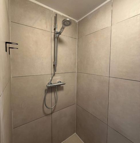 a shower stall with a shower head on a wall at Cozy Private Room 6 with Balcony in Eindhoven