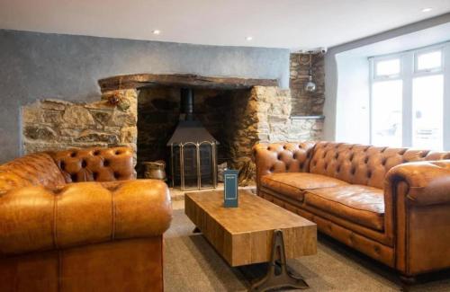 a living room with two brown leather couches and a fireplace at Sea Breeze Escape in Cubert
