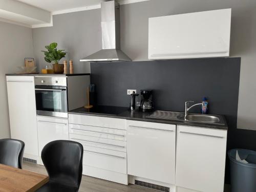 a kitchen with white cabinets and a sink at Apartment Nikki in Medebach