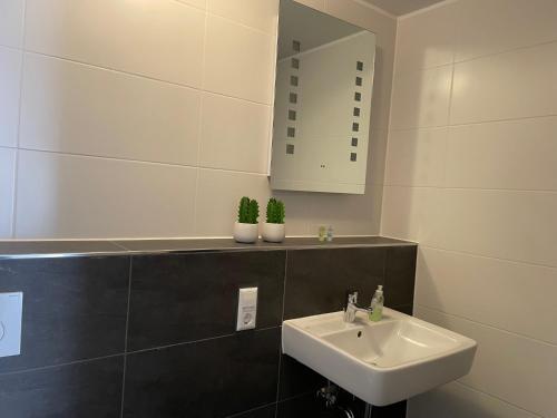a white bathroom with a sink and a mirror at Apartment Nikki in Medebach