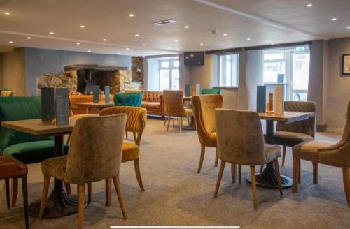 a restaurant with tables and chairs and a fireplace at Sea Breeze Escape in Cubert
