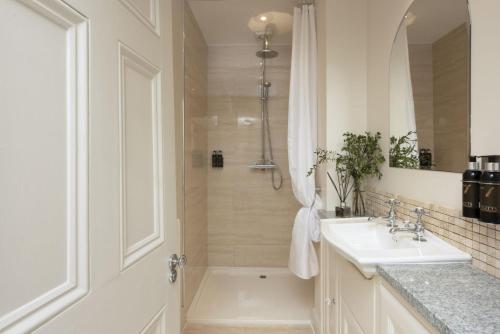 a bathroom with a tub and a sink and a shower at Dolly's Plaice, Fowey in Fowey