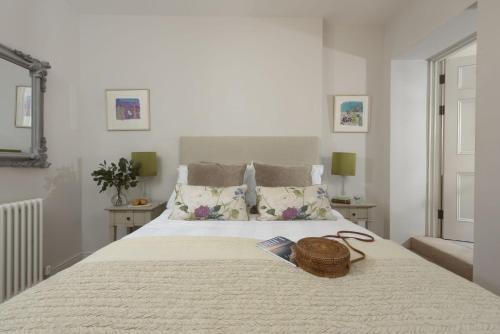 a bedroom with a bed with a basket on it at Dolly's Plaice, Fowey in Fowey