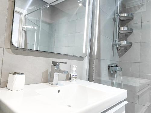 a white bathroom with a sink and a mirror at Poolfront Apartment Close to Beach in Tamaris