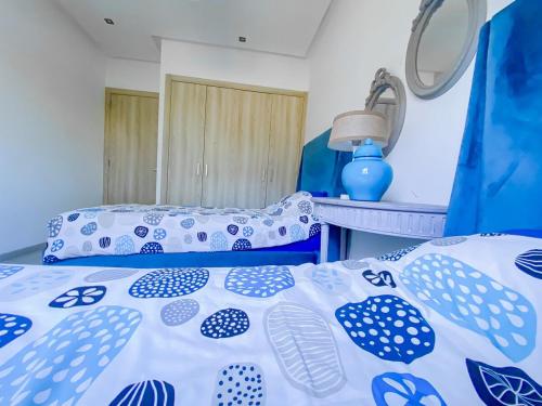 a bedroom with a bed with blue and white sheets at Poolfront Apartment Close to Beach in Tamaris