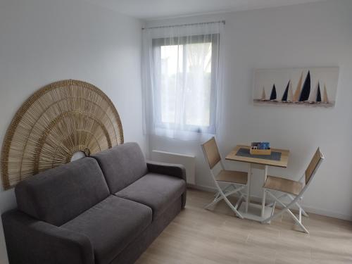 un salon avec un canapé et une table dans l'établissement Studio résidence les Miramars, au Barcarès