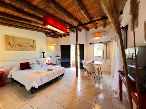 a bedroom with a bed and a table in it at Brisas de Brandsen, Chacras con estilo in Loma Verde
