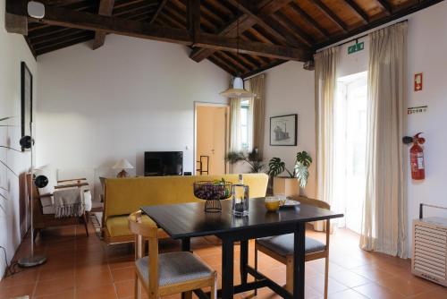 a living room with a table and chairs at Pico do Refúgio - Casas de Campo in Ribeira Grande