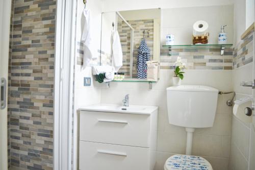 a bathroom with a toilet and a sink and a mirror at Rigoletto Cilento with private garden and pool in Eredita