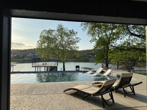 a pool with chairs and a view of a lake at Por Que No Los Dos in Marble Falls