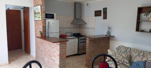 a kitchen with a brick stove and a refrigerator at Departamento cerca de la Basilica de Luján in Luján