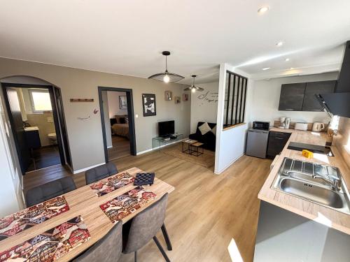 - une cuisine et un salon avec une table et un comptoir dans l'établissement Les Reflets du Château - Parking Gratuit - Cosy & Moderne - Route des vins, à Thanvillé