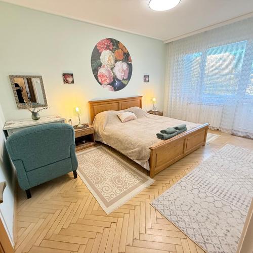 a bedroom with a bed and a chair and a mirror at Апартамент ГТ in Plovdiv