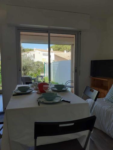 - une table avec des bols et des assiettes dans une pièce dans l'établissement 005 ipanema L'esCapAgde, au Cap d'Agde