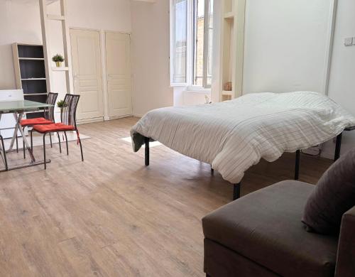 une chambre avec un lit, une table et des chaises dans l'établissement Idéal pour un court séjour, à Caveirac