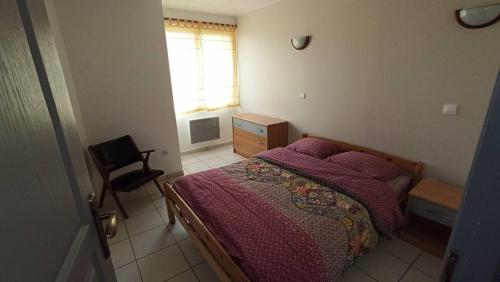 une chambre avec un lit, une fenêtre et une chaise dans l'établissement Maison proche parc Disney, à Montry