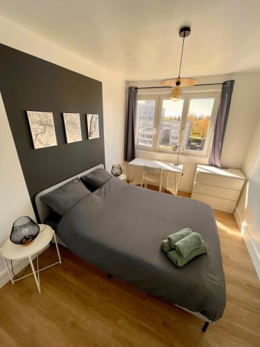 une chambre avec un grand lit et une table dans l'établissement Appartement 3 Chambres & Dernier étage, à Amiens