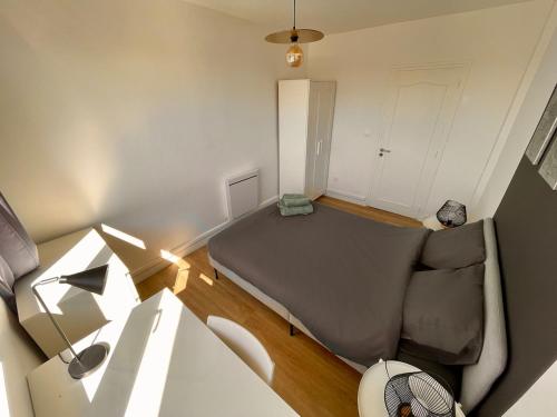 un salon avec un canapé et une chaise dans l'établissement Appartement 3 Chambres & Dernier étage, à Amiens