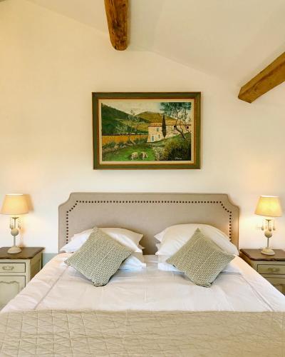 a bedroom with a white bed with two pillows at Domaine de La Brave in Pernes-les-Fontaines