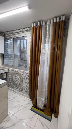 a kitchen with brown curtains and a window at Studio moderne LCE in Douala