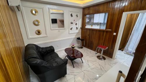 Studio moderne LCE في دوالا: غرفة معيشة مع أريكة جلدية وطاولة