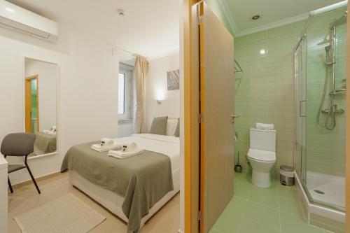 a bathroom with a bed and a shower and a toilet at Downtown Lisbon Suites by Hosty in Lisbon