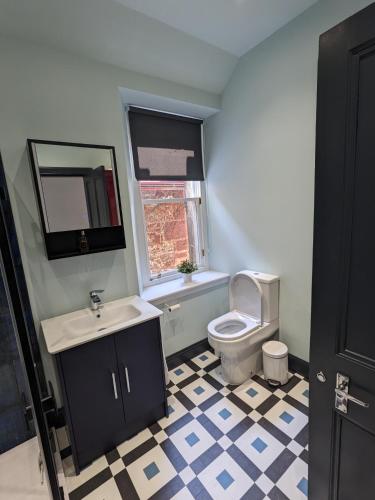 a bathroom with a sink and a toilet and a window at Sandstones in North Berwick