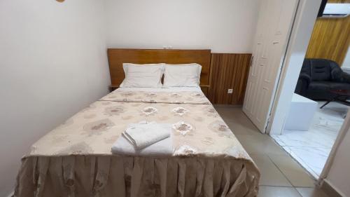 Studio moderne LCE في دوالا: غرفة نوم بها سرير وبطانية عليه