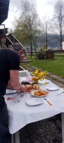 a man sitting at a table with plates of food at La casa dello scoiattolo primierotto in Tonadico
