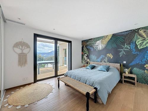 une chambre avec un lit et une grande fenêtre dans l'établissement Villa avec vue panoramique sur la baie, à Calvi