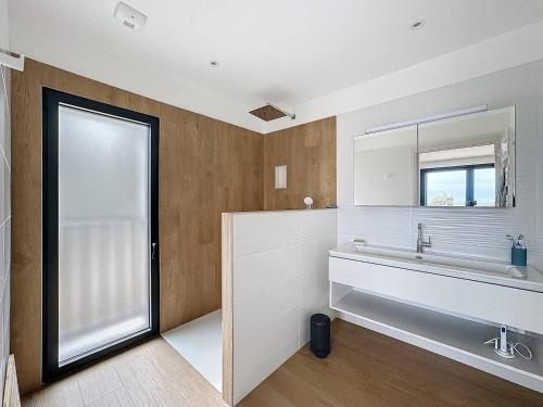 une salle de bain avec un lavabo et un miroir dans l'établissement Villa avec vue panoramique sur la baie, à Calvi