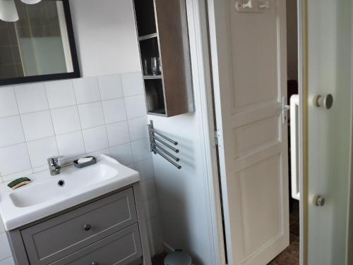 une salle de bain avec un lavabo et un miroir dans l'établissement La Coquerie, à Fondettes