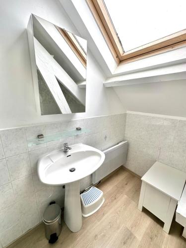 une salle de bain avec un lavabo blanc et une lucarne dans l'établissement Family apartment 5 minutes from Berck Beach, à Berck-sur-Mer