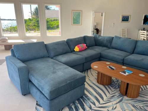 a living room with a blue couch and a coffee table at Jolly Rancher Exuma 5 bed 6 bath multi family in Georgetown