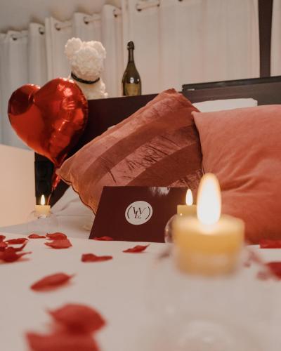 a table with a candle and a heart and a bottle of wine at Serenity Villa - Détente & Chill in Cormeilles-en-Parisis