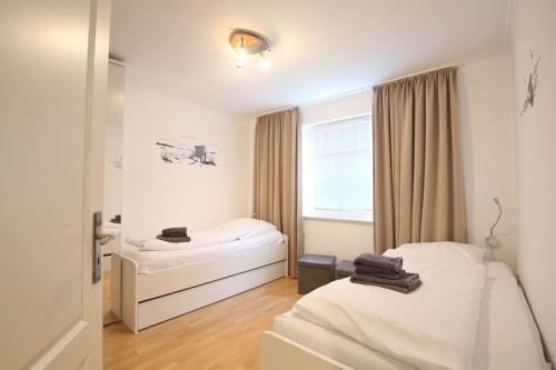 a small room with two beds and a window at Wohnung Aurora im Haus Nautilus in Wangerooge