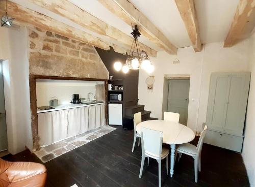 une cuisine et une salle à manger avec une table et des chaises dans l'établissement A l'Epicerie, à Caniac-du-Causse