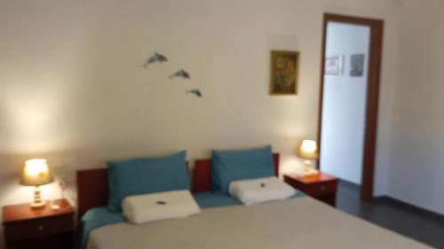 a bedroom with a bed and two blue pillows at Captain`s Place in Alexandroupoli