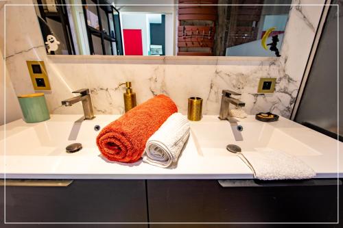 un lavabo de salle de bain avec une serviette orange dessus dans l'établissement Design YourHostHelper, à Cannes