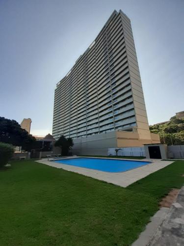 a large building with a swimming pool in front of it at Stella Maris 194 Amazimtoti Self Catering accommodation in Amanzimtoti