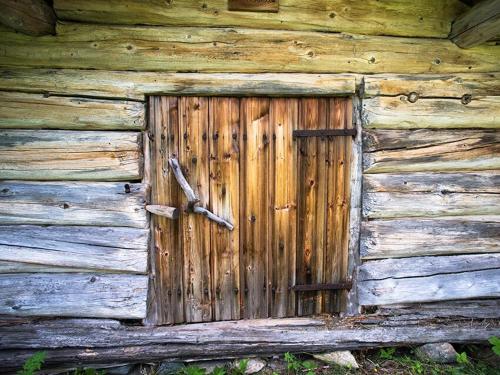 a wooden door on the side of a log cabin at Unigue mountain lodge in the heart of Jämtland in Undersåker