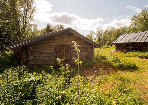 an old log cabin in the middle of a field at Unigue mountain lodge in the heart of Jämtland in Undersåker